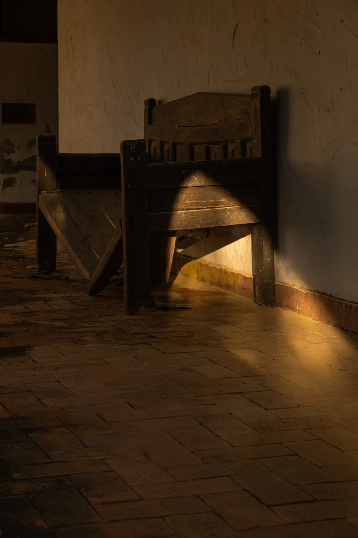 A wooden chair in a shaft of golden light